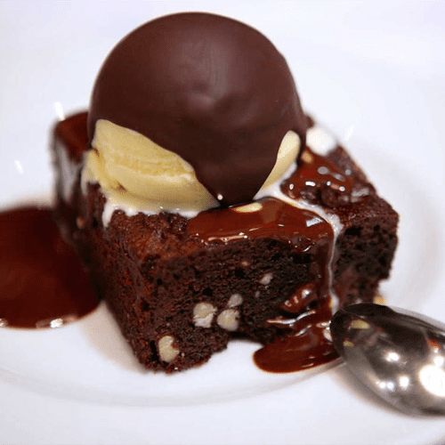 Brownie de chocolate, nueces y arándanos con helado de vainilla, chocolate caliente y crocanti